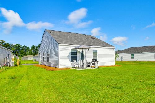 a white barn with a table and chairs in a yard at Brand-New Savannah Area Home 15 Mi to Dtwn! in Port Wentworth