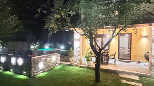 a backyard at night with a tree and lights at Natura Bungalows-Villa in Limenas