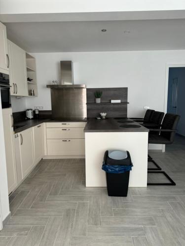 a kitchen with white cabinets and a black counter top at Smile home, Zaanse schans and Amsterdam Appartements in Wormerveer