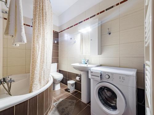 a bathroom with a washing machine and a toilet and a sink at Holiday home with panoramic view of the forest in Polykhrono