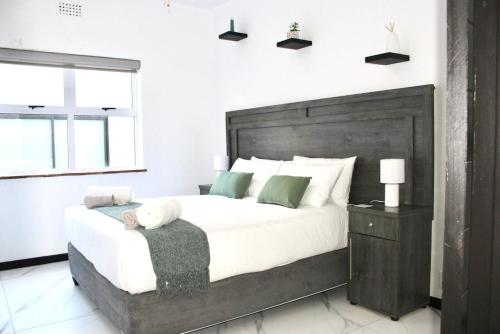 a bedroom with a large bed with a teddy bear on it at Sea and Mountain View Apartment in Cape Town