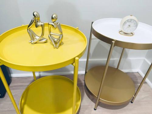 a couple of yellow tables with a clock on a side table at Designer 3BDR Penthouse with Private Rooftop Monument Views Near Popular H Street Corridor Parking Included Free Cancellation in Washington