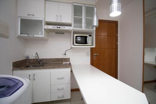 a small kitchen with a sink and a microwave at OZPED Flats Particulares Edifício Life Resort in Brasilia