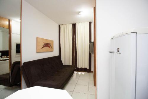a living room with a couch and a refrigerator at OZPED Flats Particulares Edifício Life Resort in Brasilia