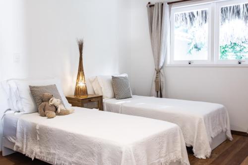 a teddy bear sitting on a bed in a bedroom at Preabeach Boutique Hotel & SPA in Prea