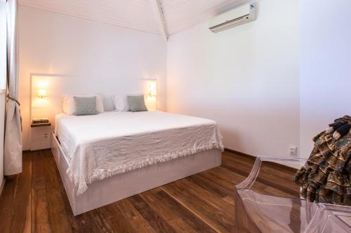 a bedroom with a white bed and a wooden floor at Preabeach Boutique Hotel & SPA in Prea