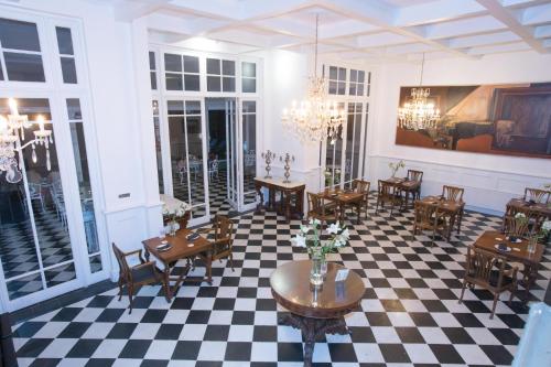 a restaurant with tables and chairs on a checkered floor at Hotel Isla Seca in Zapallar