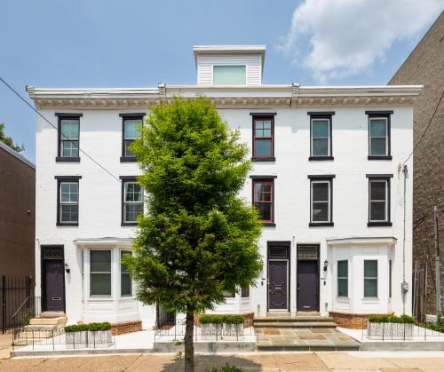 a white building with a tree in front of it at Your Perch at University City in Philadelphia