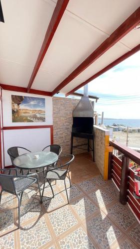 a patio with a table and chairs and a stove at Bahía Loreto in Caldera