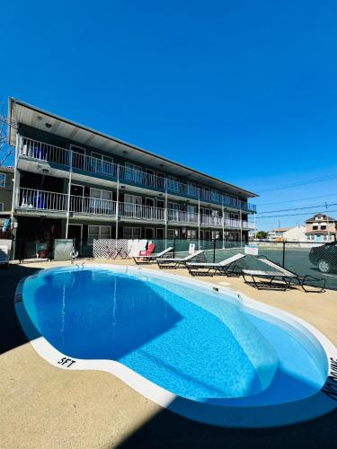 an empty swimming pool in front of a building at Seagem Motel and Apartments in Seaside Heights