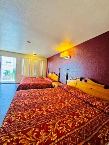 a large bedroom with two beds with red walls at Seagem Motel and Apartments in Seaside Heights