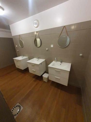 une salle de bain avec deux lavabos et deux miroirs dans l'établissement Les gîtes du château du cèdre, à Manneville-ès-Plains