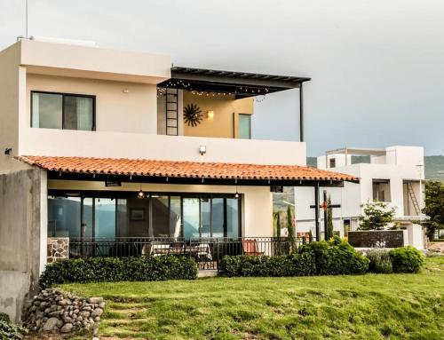 a house with a lawn in front of it at Quinta San José casa del Lago in Jocotepec