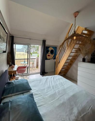 une chambre avec un grand lit et un escalier dans l'établissement Ile tudy Bord de plage et farniente en terrasse Appt classé 3 étoiles, à l'Île-Tudy