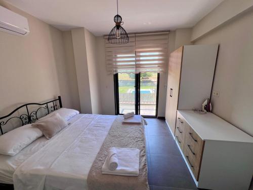 a bedroom with a large white bed and a window at Göcek Villa Hayal in İnlice