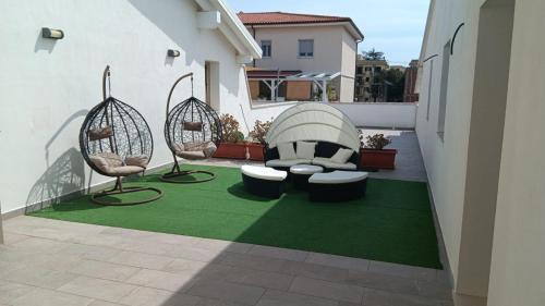 a patio with two chairs and a green rug at La Perla Amantea - Rooms & Apartaments in Amantea
