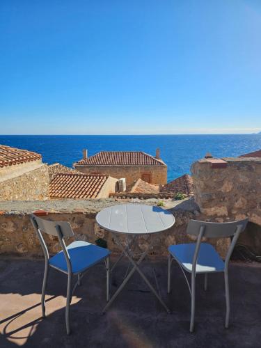 a white table and two chairs and the ocean at Byzantino Boutique Hotel in Monemvasia