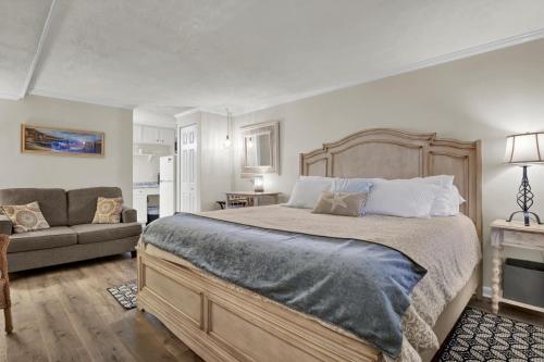 Un dormitorio con una cama grande y un sofá. en The Waterway 115 by Sea Scape Properties, en Wrightsville Beach