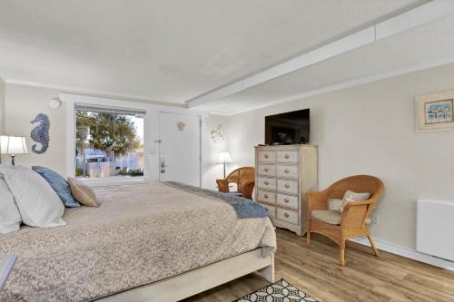 a bedroom with a bed and a window and a dresser at The Waterway 115 by Sea Scape Properties in Wrightsville Beach