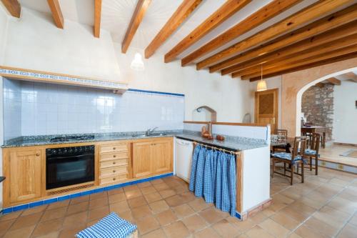 a kitchen with wooden cabinets and a counter top at Ses Roques in Santa Maria del Camí