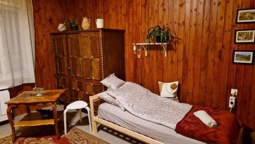 a bedroom with a bed and a wooden wall at Garan Vendégház in Jósvafő