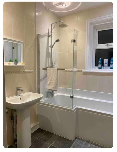 a bathroom with a tub and a sink and a shower at Beautiful Garden Flat in Bournemouth - First Floor in Bournemouth