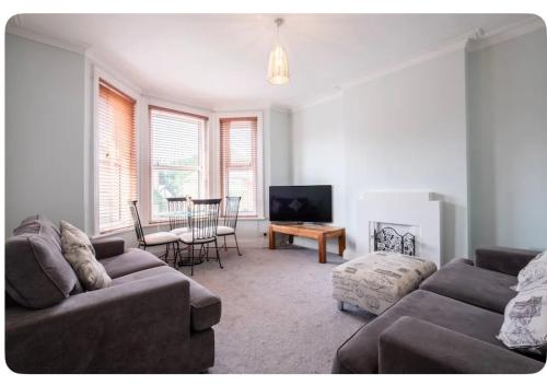a living room with a couch and a table at Beautiful Garden Flat in Bournemouth - First Floor in Bournemouth