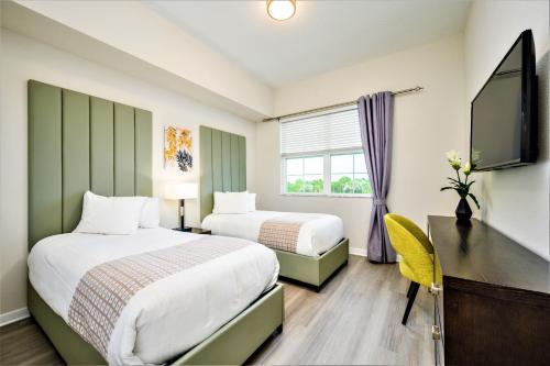 a hotel room with two beds and a television at Vista Cay Resort by Millenium at Universal Blvd. in Orlando