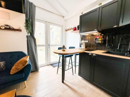 a kitchen with black cabinets and a wooden counter top at Suite romantique JACUZZI privatif chauffé à 37 GARE in Guingamp