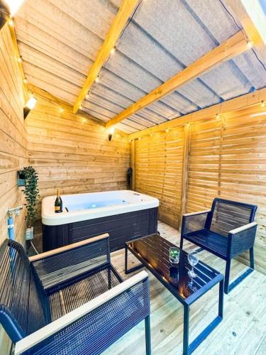 Cette chambre dispose d'une baignoire, de deux chaises et d'une table. dans l'établissement Suite romantique JACUZZI privatif chauffé à 37 GARE, à Guingamp