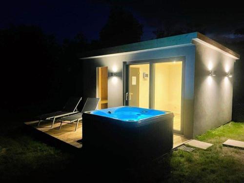 a small house with a hot tub in the yard at night at Ferienwohnung-Frees-Mooi in Neßmersiel