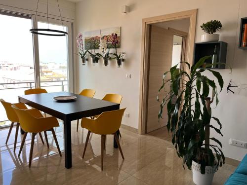 a dining room with a table and chairs and a plant at Marconi Skyline in Bologna