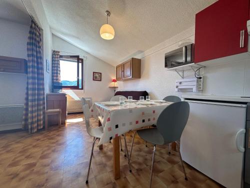 une cuisine avec une table et des chaises dans une pièce dans l'établissement Appartement familial au pied des pistes avec balcon à Samoëns 1600 - FR-1-624-79, à Samoëns