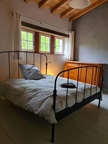 une chambre avec un lit dans une pièce avec des fenêtres dans l'établissement La Bouchonnière, maison dans un hameau de vacances, à Monflanquin