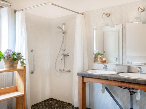 une salle de bain avec deux lavabos et une douche dans l'établissement La Bouchonnière, maison dans un hameau de vacances, à Monflanquin