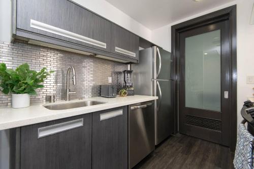 a kitchen with a sink and a refrigerator at Audemar Boutique Hotel and Apartment Homes in Los Angeles