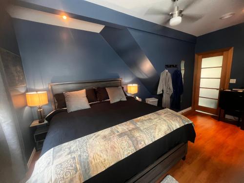 a bedroom with a large bed with a blue wall at Sunset Suites in Niagara Wine Country in Niagara on the Lake