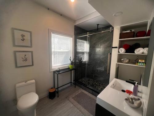 a bathroom with a shower and a toilet and a sink at Sunset Suites in Niagara Wine Country in Niagara on the Lake