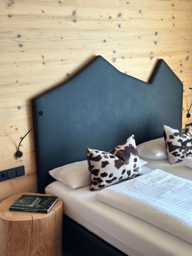 a bedroom with a bed with a headboard and a table at Bergwelt Kandel Hotel & Eventlocation in Waldkirch