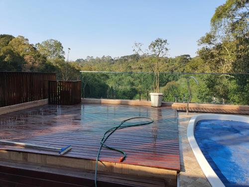 una piscina en una terraza al lado de una piscina en Chácara c piscina, en Cotia