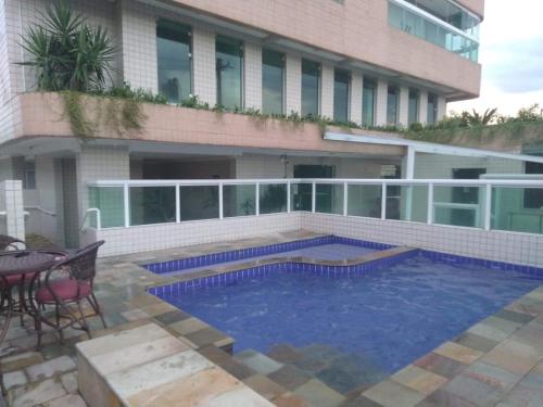 a swimming pool in front of a building at Apê Temporada II Praia Grande SP Completo com Piscina, Churrasqueira, Estacionamento in Praia Grande