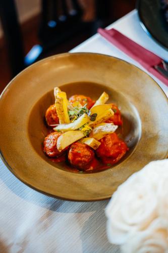 a wooden bowl of food with meatballs and vegetables at Hotel Palacio de Hemingway in Ronda
