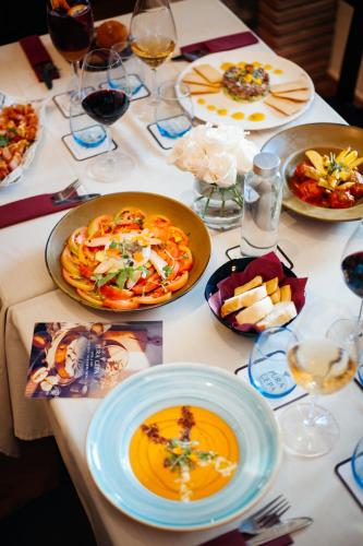 a table with plates of food and glasses of wine at Hotel Palacio de Hemingway in Ronda