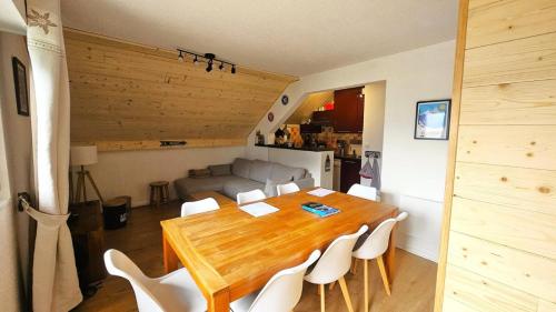 une salle à manger avec une table en bois et des chaises blanches dans l'établissement Résidence Les Maisonnettes - GRAND APPARTEMENT AU CALME - 6/7 PERS MAE-4661, à Puy-Saint-Vincent