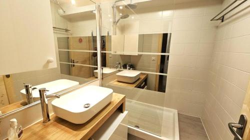 une salle de bain blanche avec un lavabo et un miroir dans l'établissement Résidence Les Maisonnettes - GRAND APPARTEMENT AU CALME - 6/7 PERS MAE-4661, à Puy-Saint-Vincent