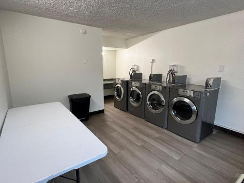a laundry room with three washing machines in it at My Home at Columbus in Columbus