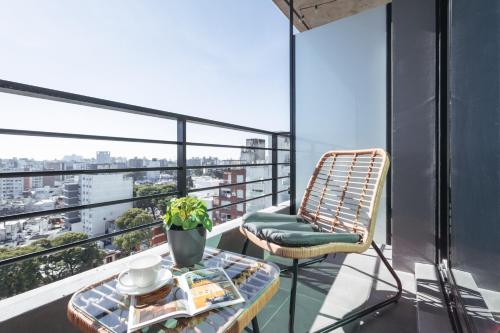 balcone con tavolo e sedia in rattan di ZENHAUS - Punta Carretas Moderno y con Vistas Despejadas a Montevideo