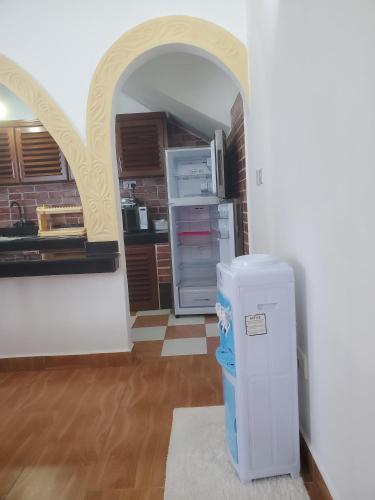a kitchen with an archway and a refrigerator at Muna Beachfront Apartment in Malindi