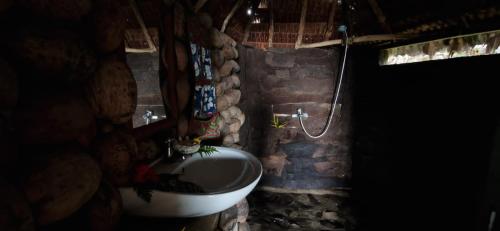 a stone bathroom with a sink and a toilet at Tanna Lava View Bungalows in Lénakel