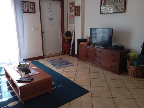 a living room with a television on a dresser at Casa Dunas in São Jacinto